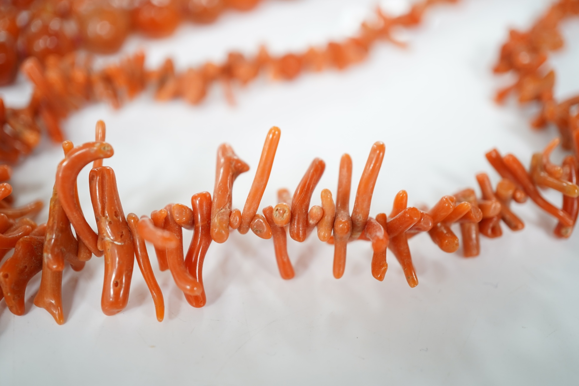 A micromosaic brooch and a group of bead necklaces, comprising: a micromosaic brooch depicting the Forum, length 4.6cm; together with a carnelian bead necklace; a coral branch necklace; and a green glass bead necklace